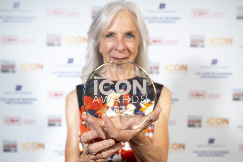 Close-up of Lisa Donnelley holding out her glass Idaho Business Review ICON Award trophy at the ceremony.